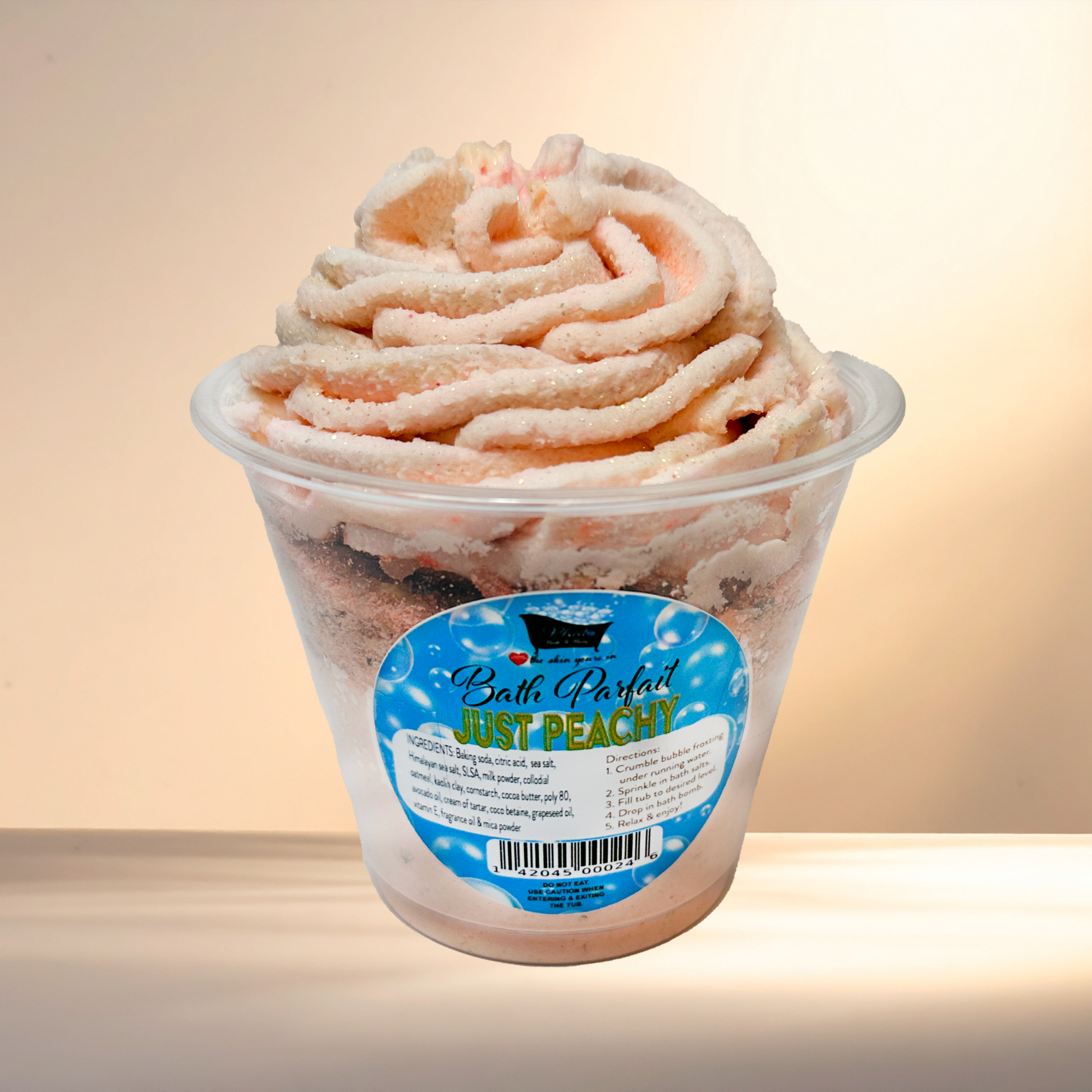 Peach Bath Parfait in a container with a label on a beige background