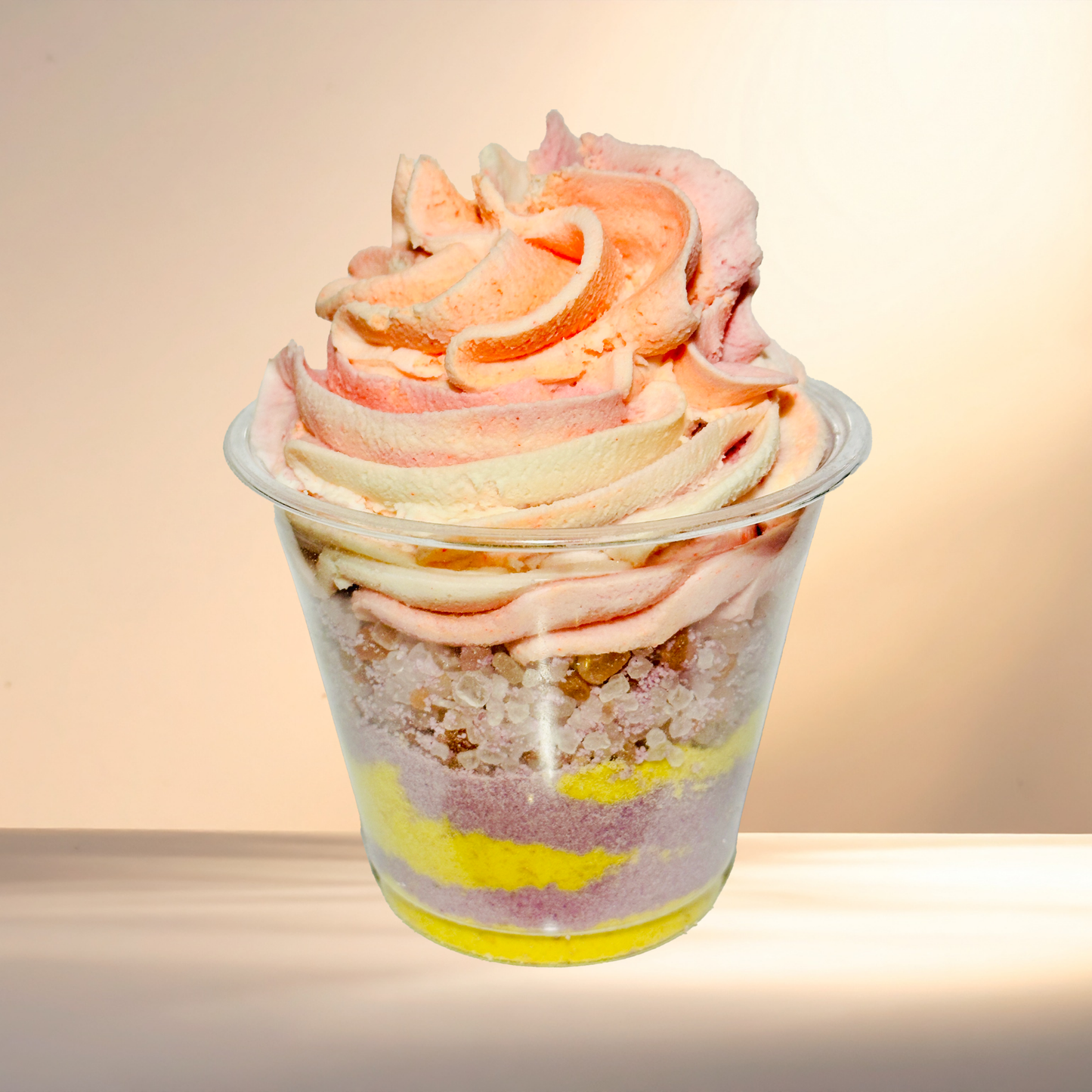 Colorful layered bubble bomb in a transparent cup with a soft focus background