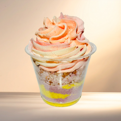 Colorful layered bubble bomb in a transparent cup with a soft focus background