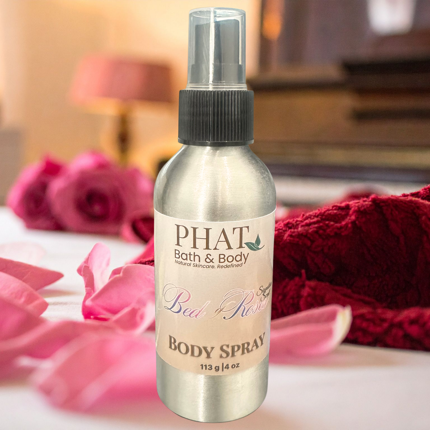 PHAT Bath & Body body spray bottle with pink roses and a red towel in the background