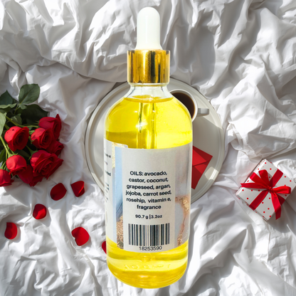 Bottle of yellow body oil with dropper on a white fabric background with red roses and a gift box.