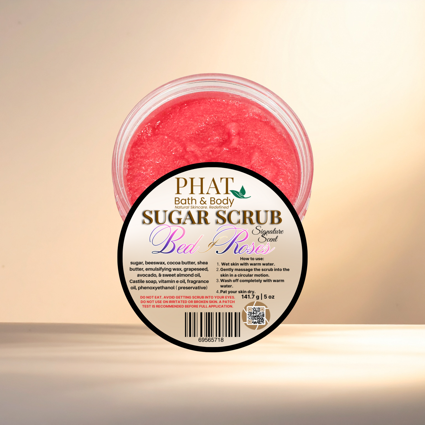Pink sugar scrub in a container with a label on a beige background