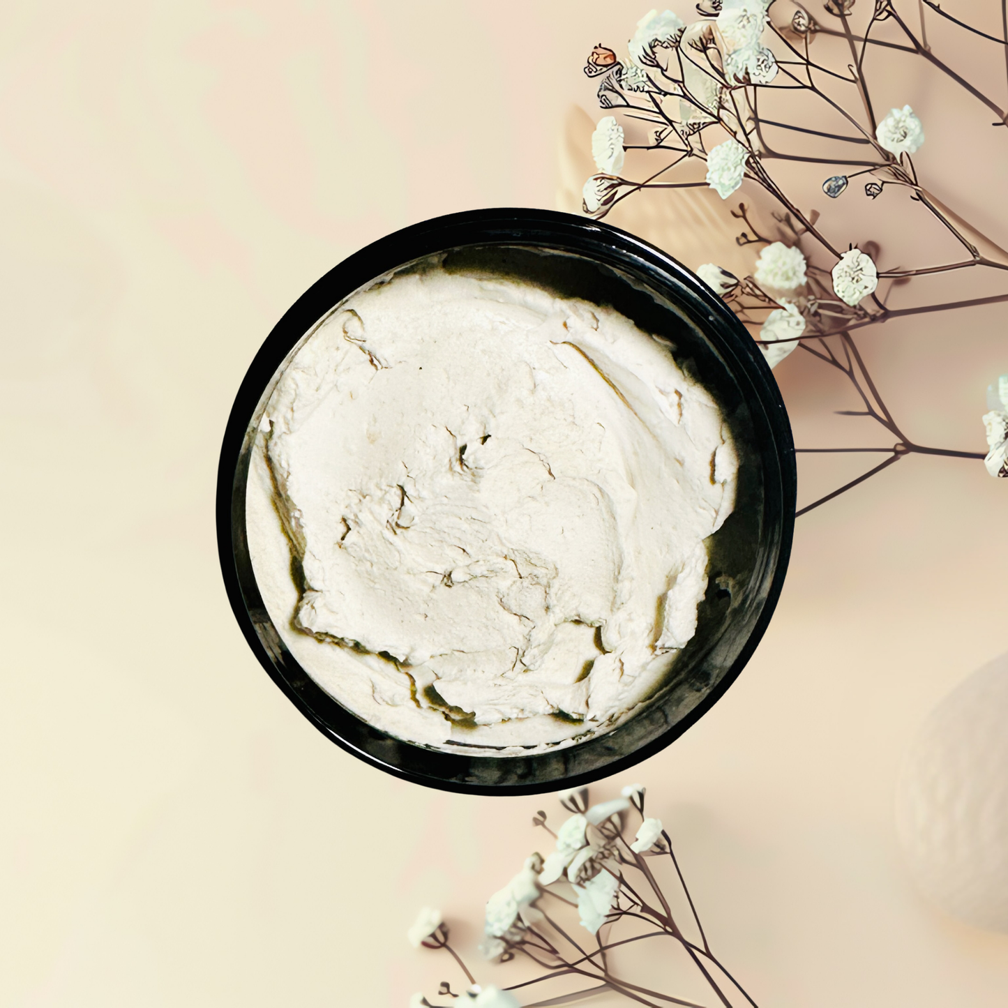Black bowl with white mask on a light pink background with white flowers