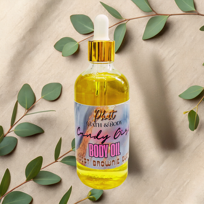 Body oil bottle with a colorful label on a beige fabric background with green leaves.
