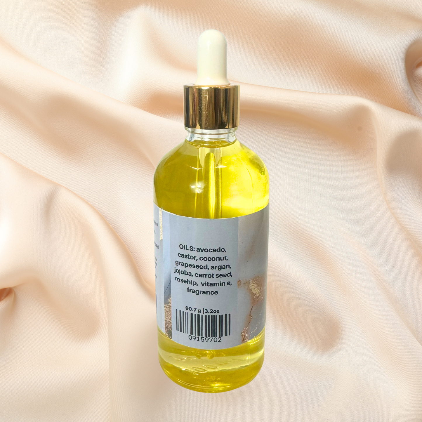 Bottle of yellow liquid with dropper on a beige fabric background