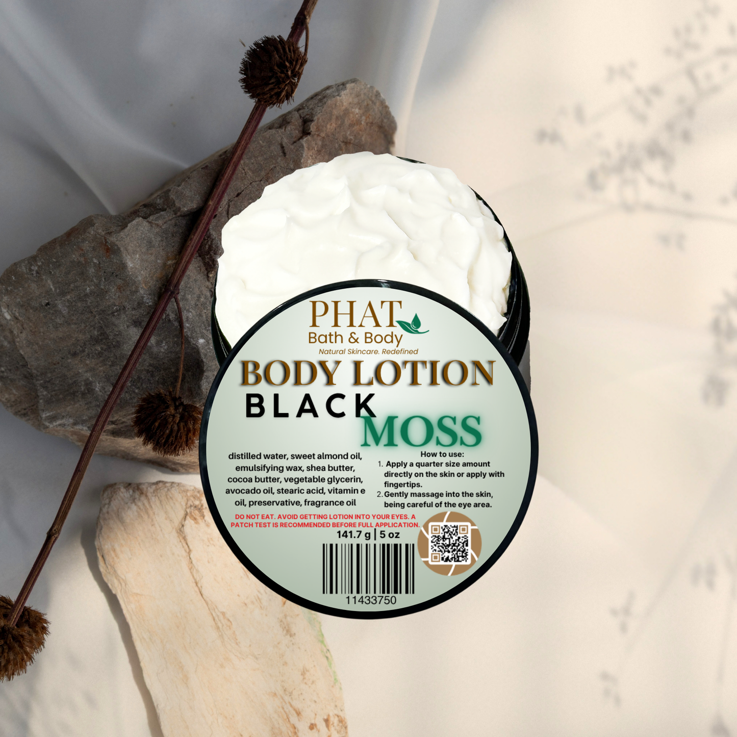Body lotion container labeled 'Black Moss' by Phat Bath & Body on a natural stone background.