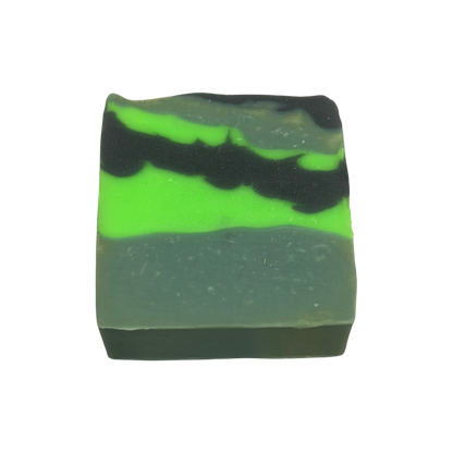 Bar of soap with green and black layers on a white background