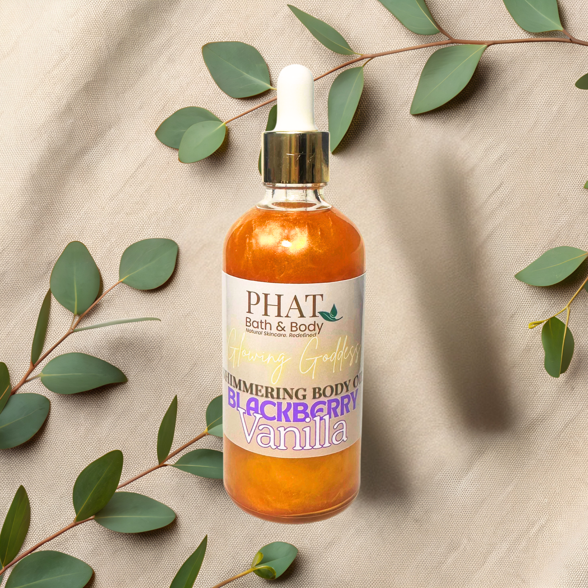 Bottle of 'PHAT Bath & Body' body oil with a label on a beige fabric background with green leaves.