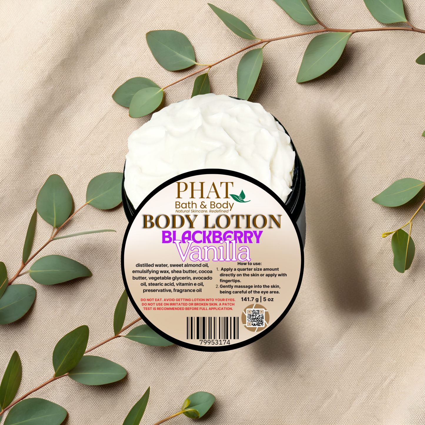 Body lotion container with 'Phat Bath & Body' label on a beige fabric background with green leaves.
