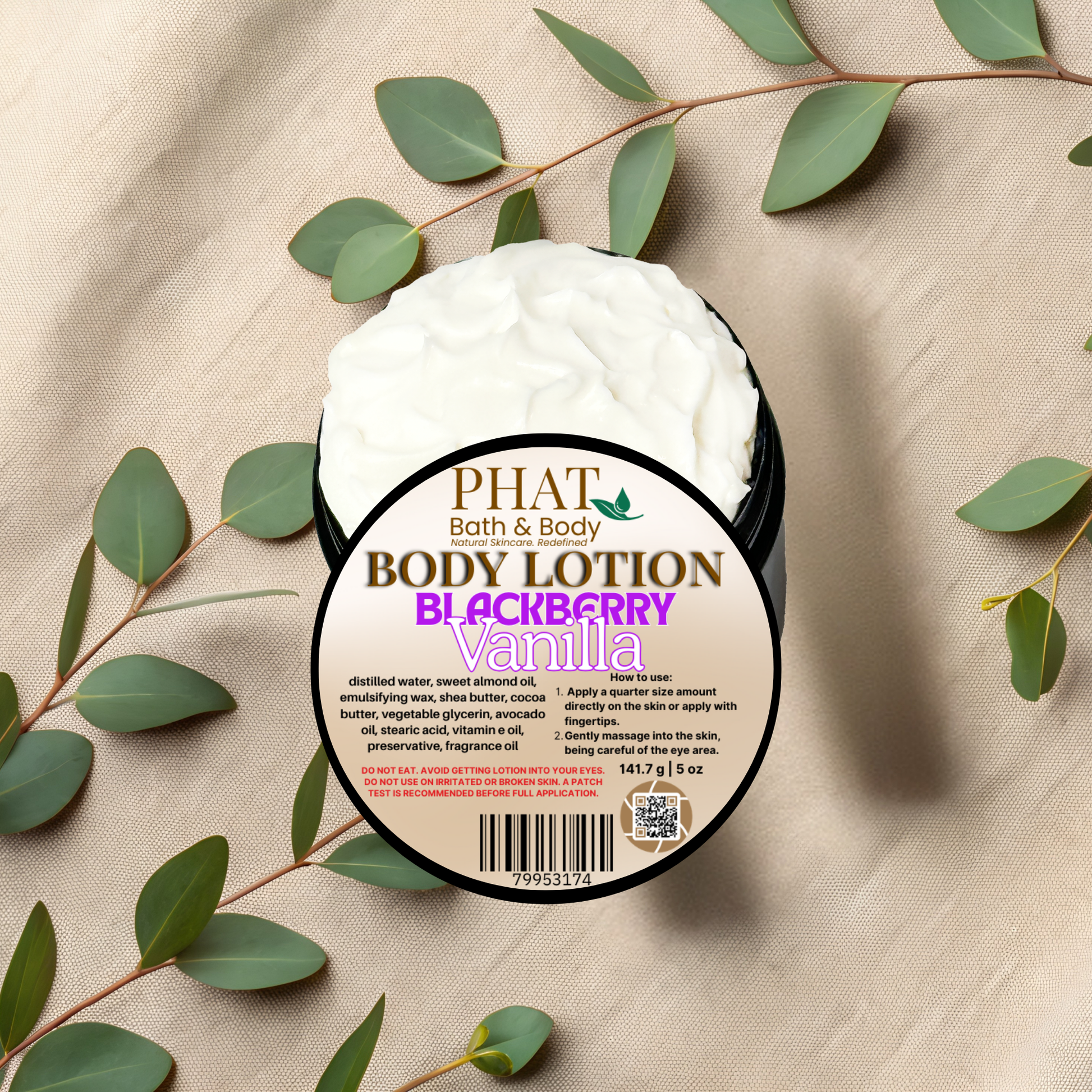 Body lotion container with 'Phat Bath & Body' label on a beige fabric background with green leaves.