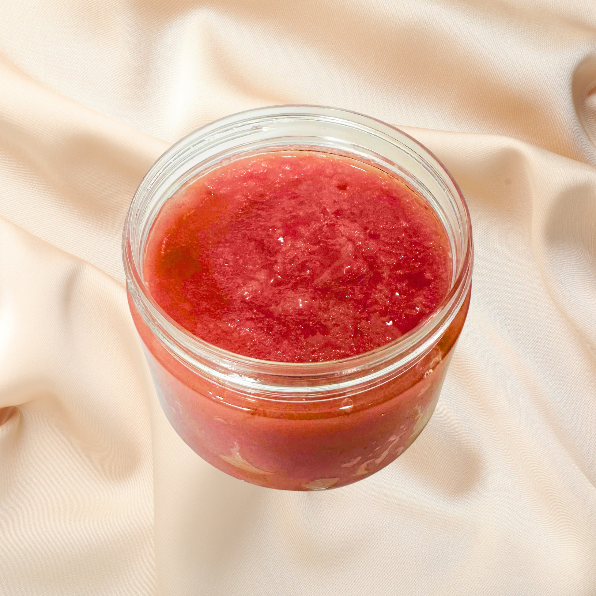Jar of red scrub on a beige fabric background