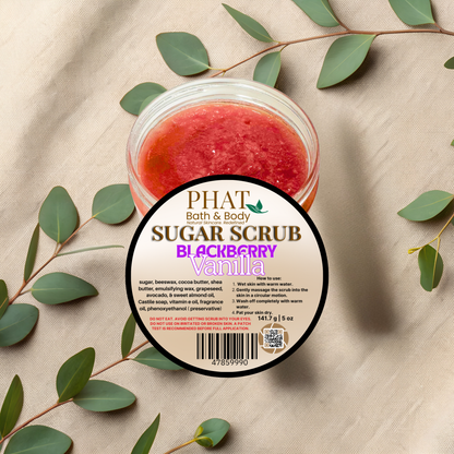 Jar of sugar scrub with blackberry vanilla scent on a beige fabric background with green leaves.