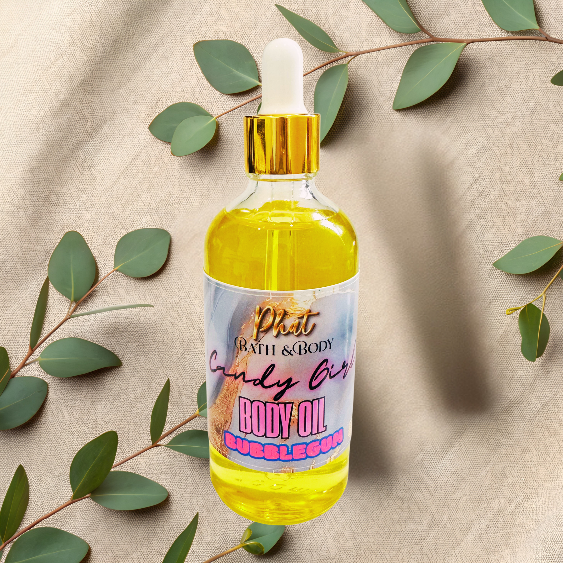 Bottle of body oil with a colorful label on a beige fabric background with green leaves.
