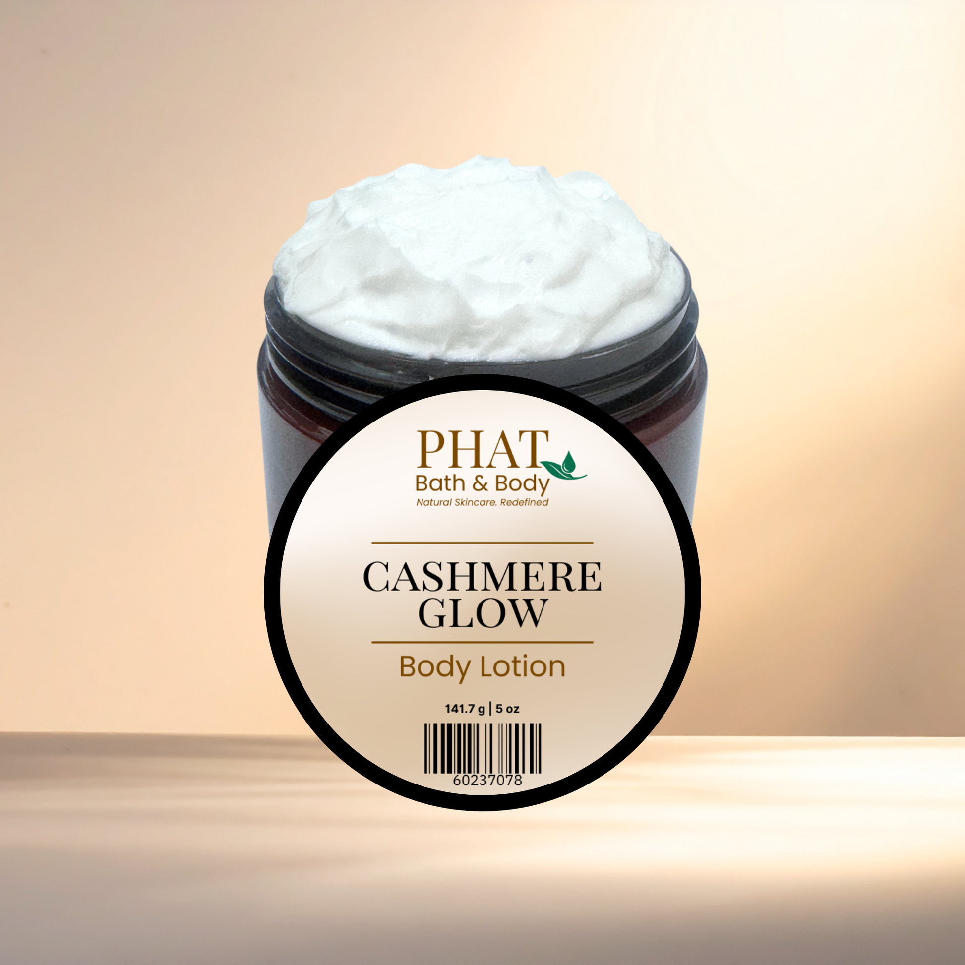 Jar of 'Cashmere Glow' body lotion with 'PHAT Bath & Body' label on a gradient background
