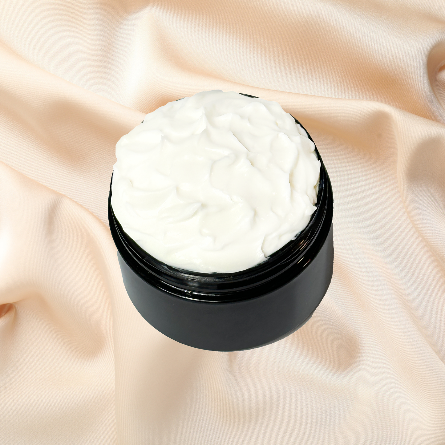 Black jar of white cream on a beige fabric background