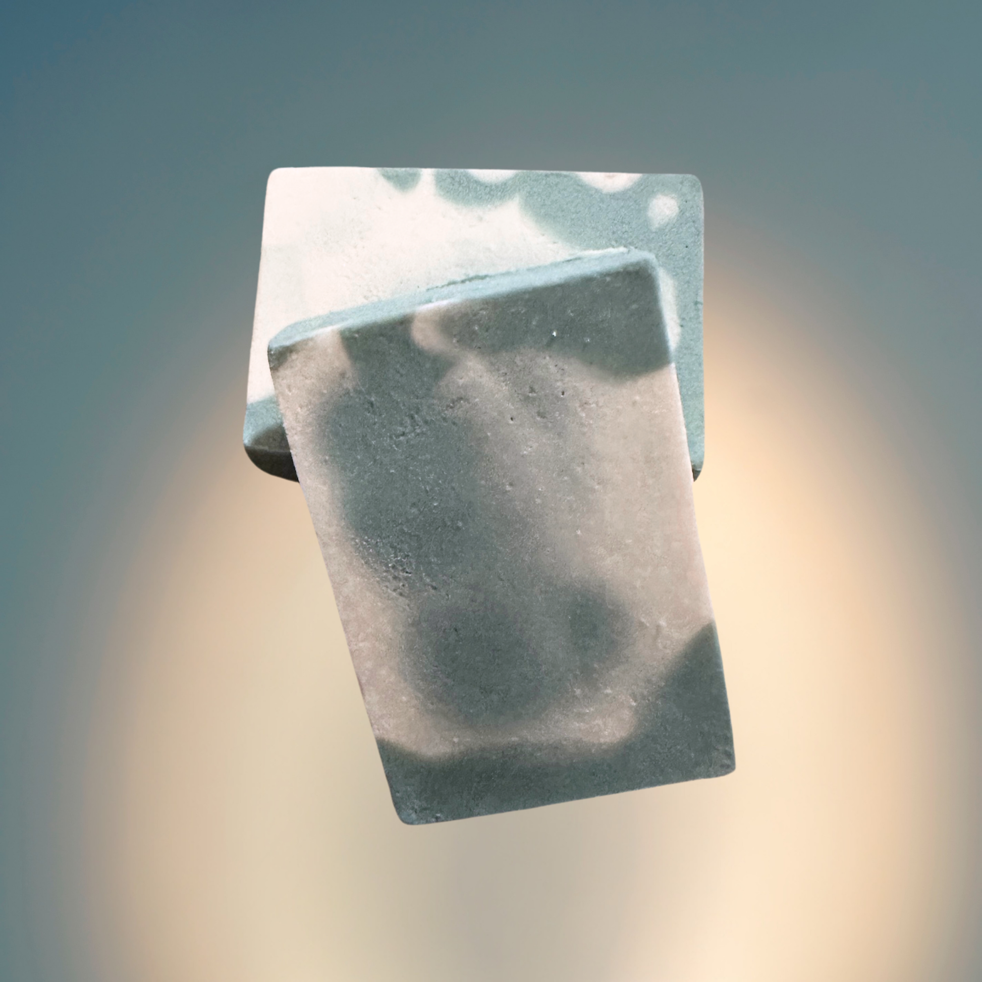 two green bars of soap with a blurred background