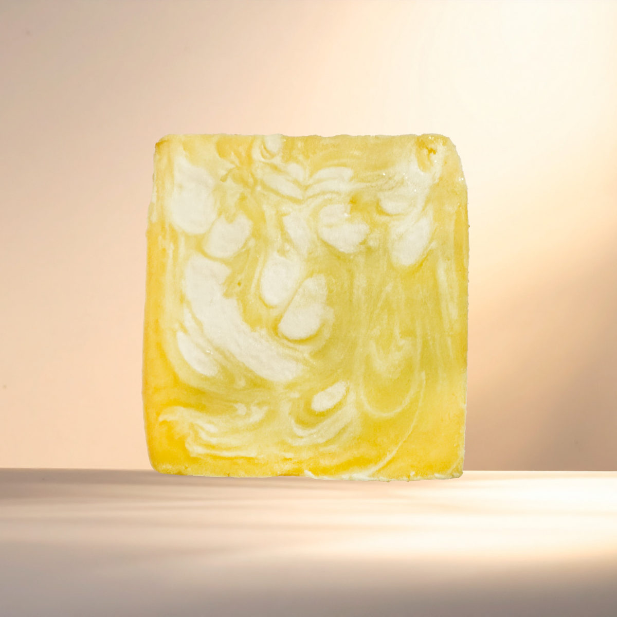 Marbled yellow and white soap bar on a neutral background