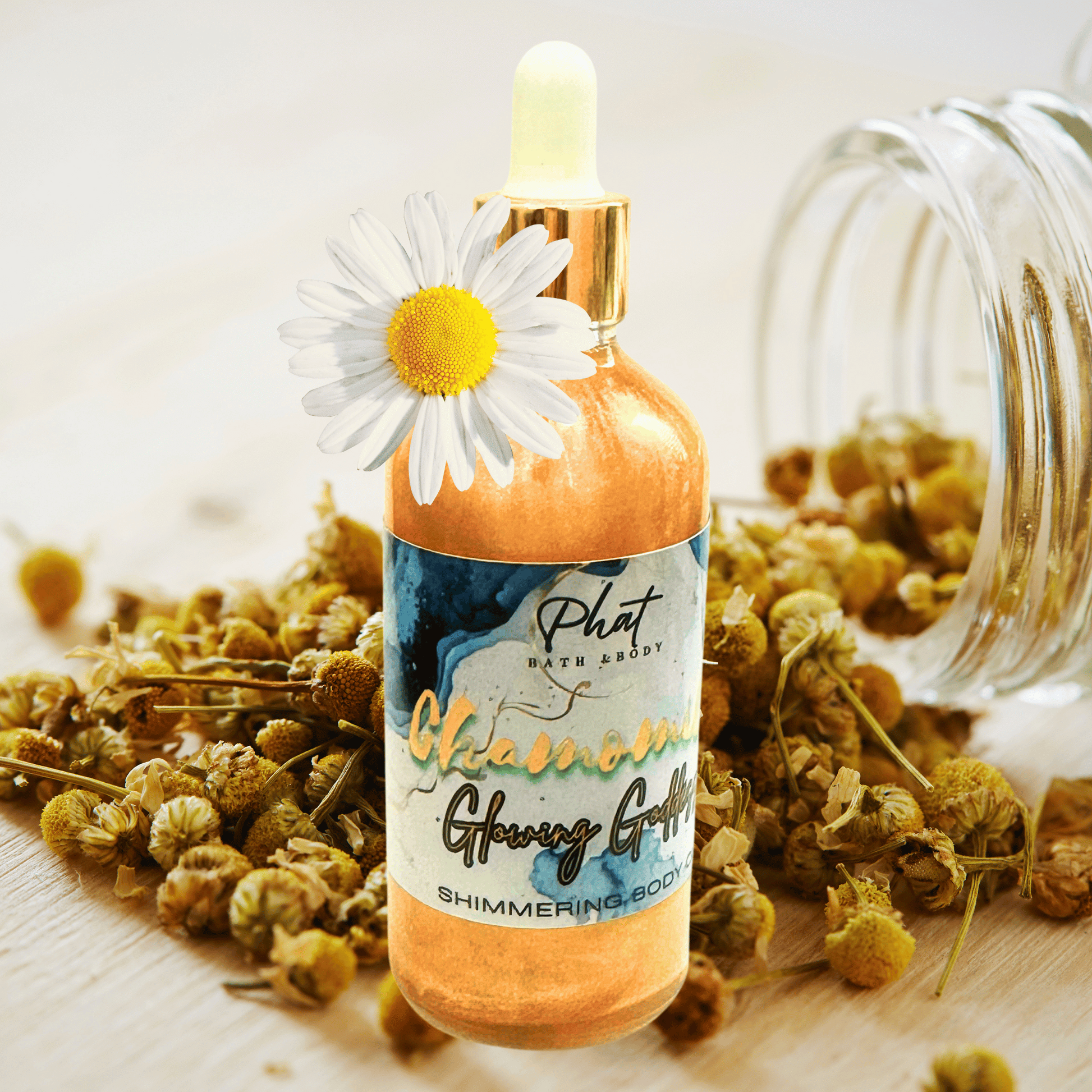 Bottle of 'Phat Bath Body' chamomile glowing griffin product with a dropper and a daisy on top, surrounded by dried flowers.