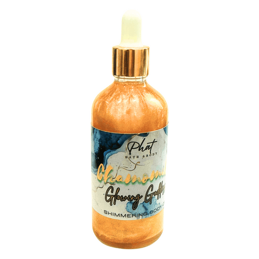 Shimmering body oil bottle with gold cap on a white background