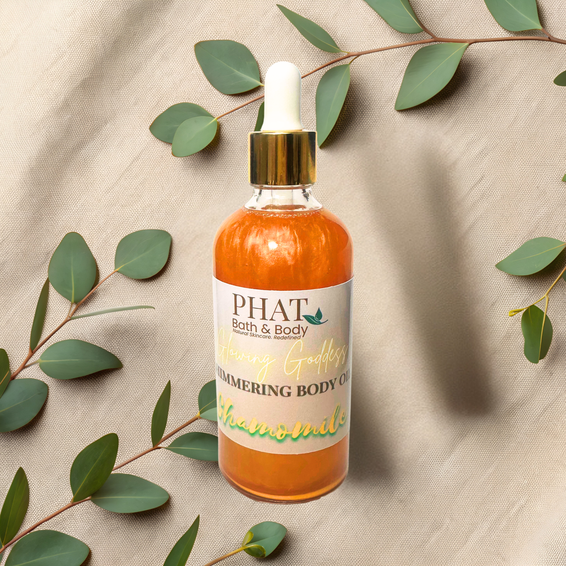 Bottle of PHAT Bath & Body chamomile body oil with a dropper on a beige fabric background with green leaves.