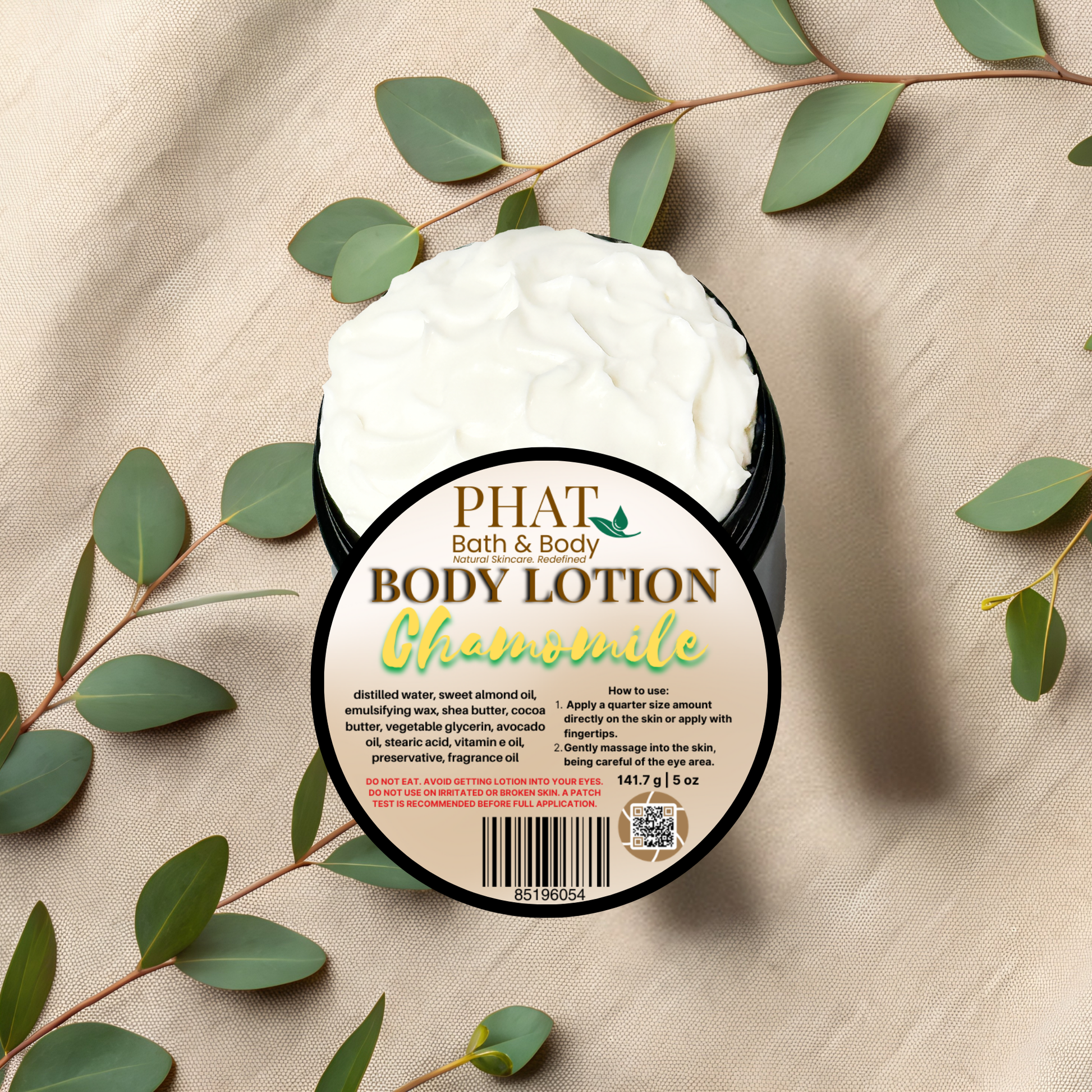 Body lotion container with Chamomile scent on a beige fabric background with green leaves.