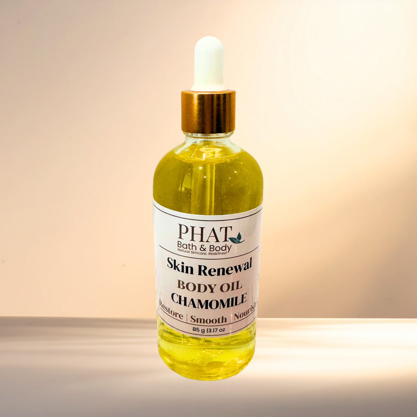 Bottle of 'Skin Renewal Body Oil Chamomile' by PHAT Bath & Body on a gradient background