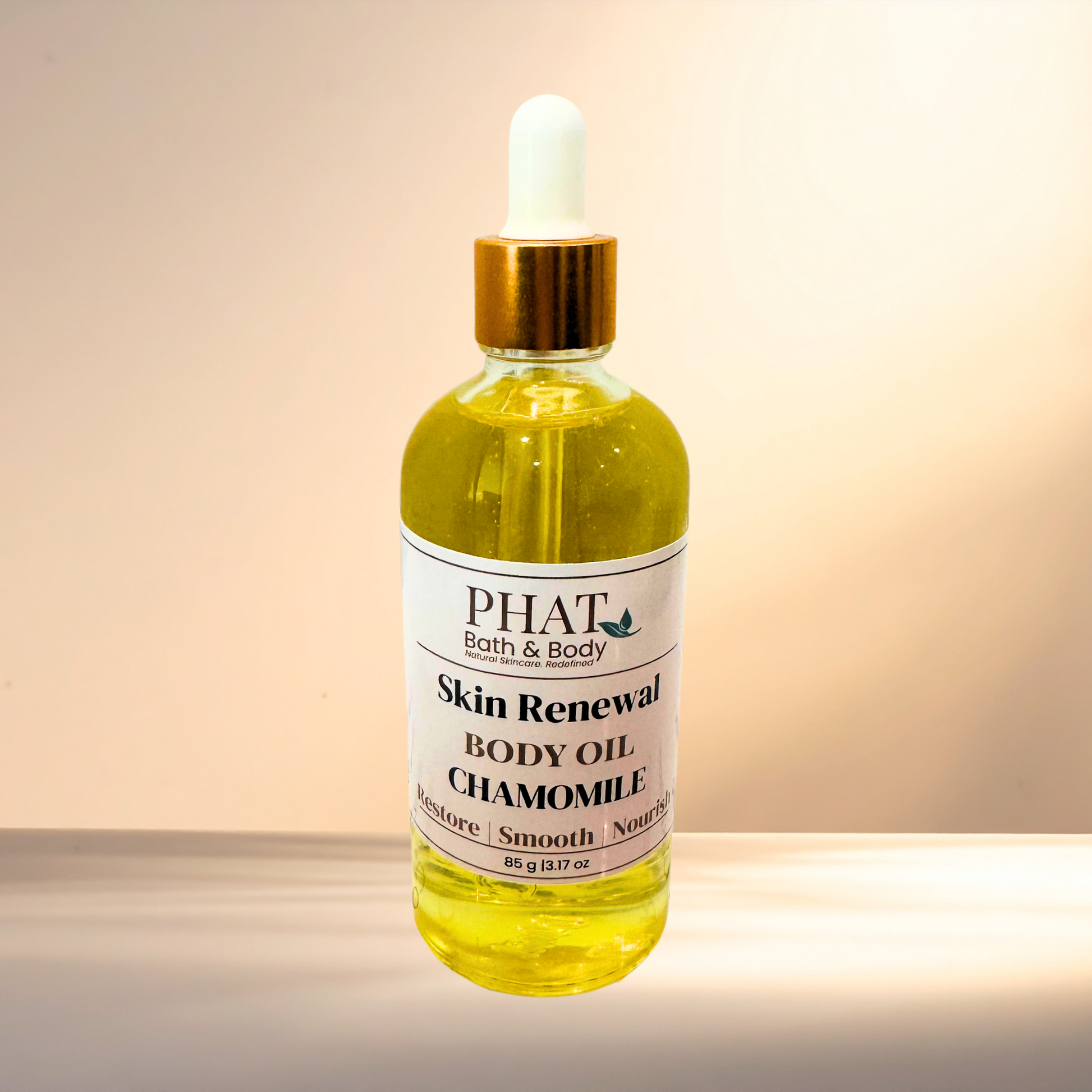 Bottle of 'Skin Renewal Body Oil Chamomile' by PHAT Bath & Body on a gradient background