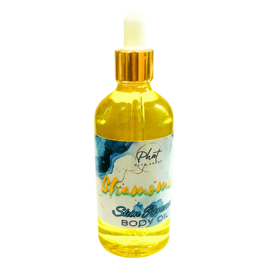 Bottle of body oil with a gold cap on a white background