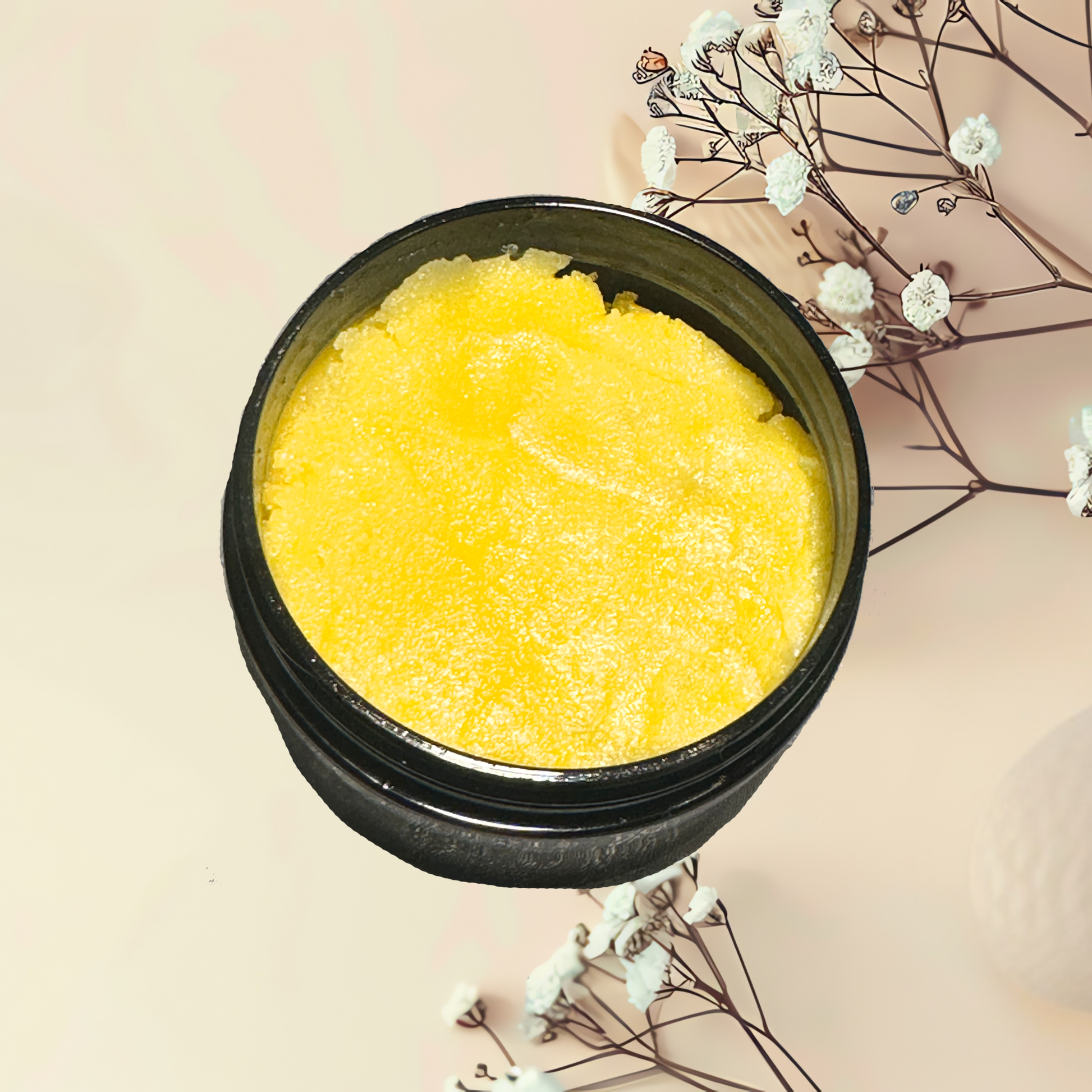 Yellow scrub in a black container with white flowers on a beige background