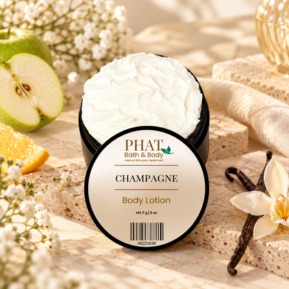 Phat Bath & Body Champagne Body Lotion styled with green apple, citrus, vanilla beans, white florals, soft fabric, and warm natural stone.