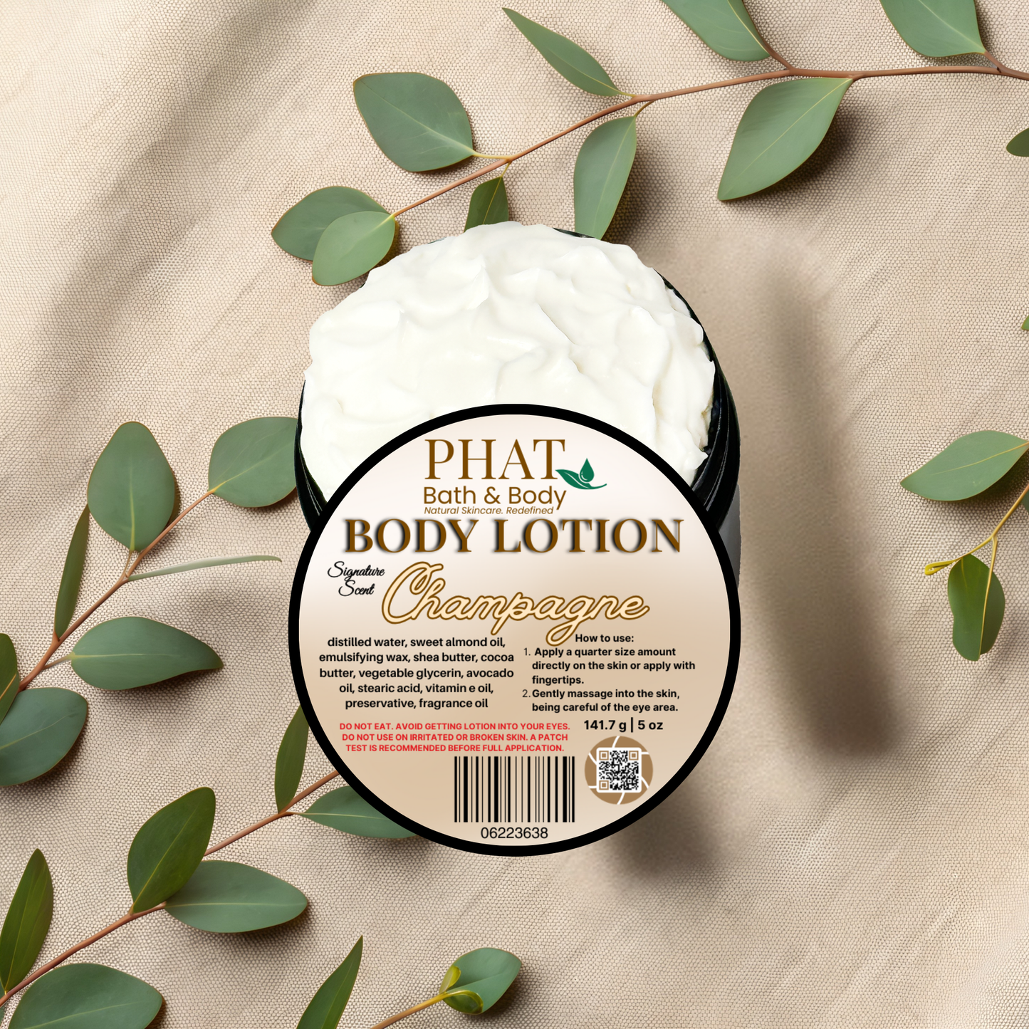 Body lotion container labeled 'PHAT Bath & Body' with green leaves on a beige fabric background