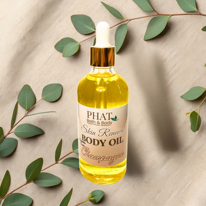 Bottle of Phat Bath & Body Skin Renewal Body Oil with a dropper on a beige fabric background with green leaves.