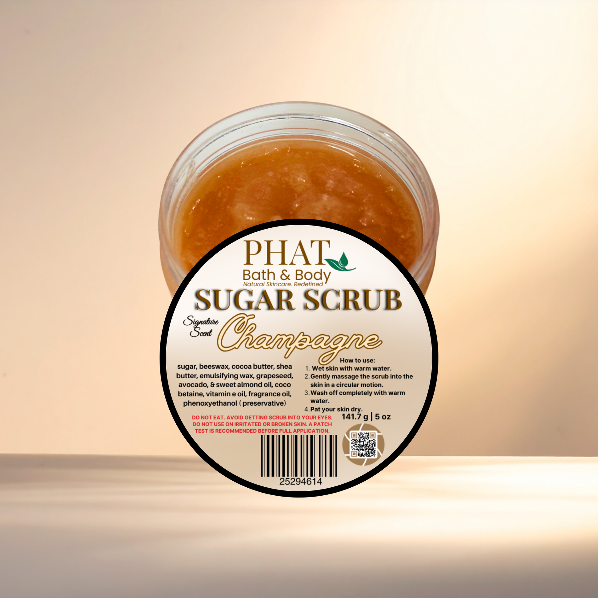 Jar of sugar scrub labeled 'PHAT Bath & Body Sugar Scrub Champagne' on a light background