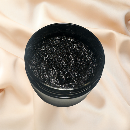 Black container of cosmetic scrub on a beige fabric background