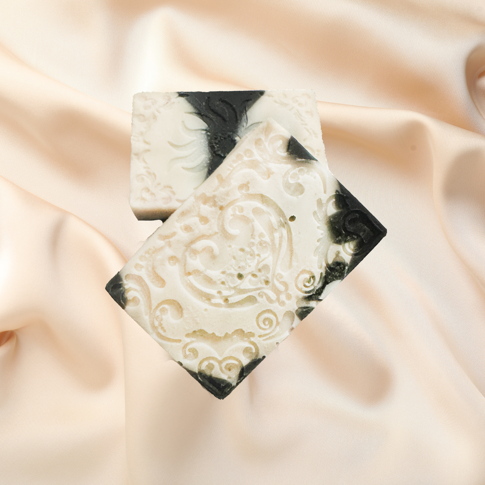 Decorative soap bar with paisley pattern on a soft fabric background