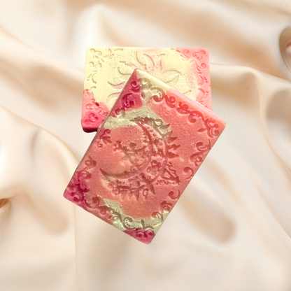 Decorative soap bars with intricate patterns on a soft fabric background