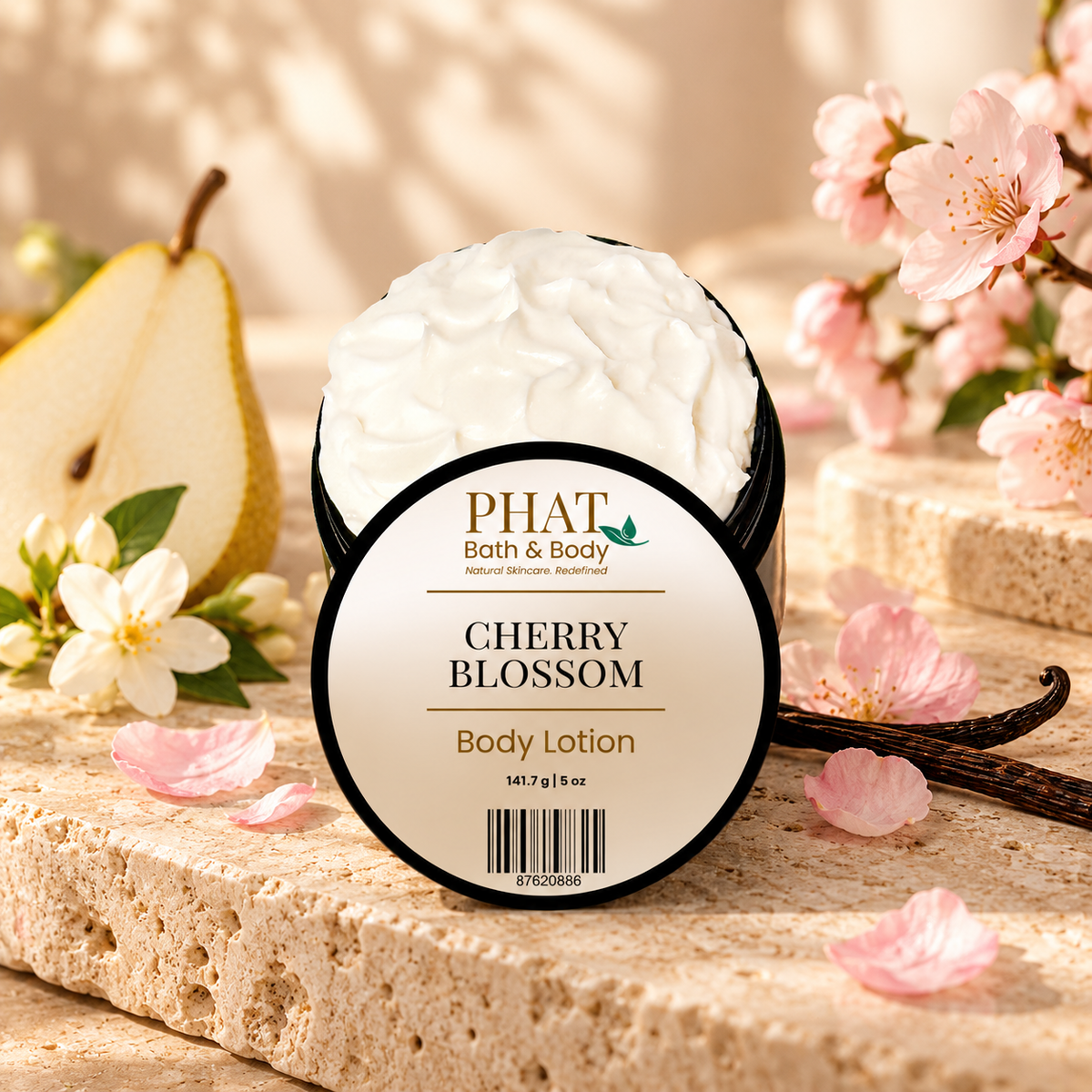 Phat Bath & Body Cherry Blossom Body Lotion with labeled lid displayed among pink blossoms, sliced pear, vanilla beans, white flowers, and soft neutral stone.