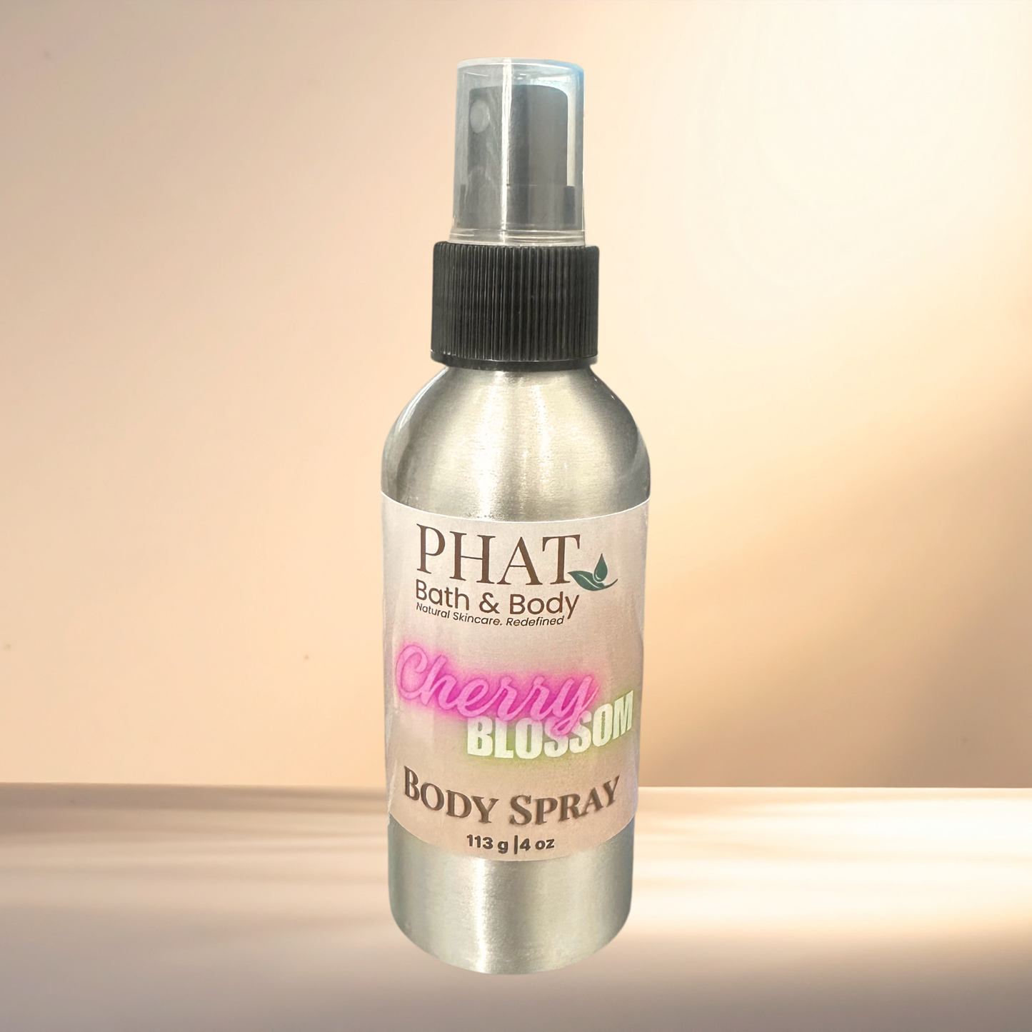 Body spray bottle labeled 'PHAT Bath & Body Cherry Blossom' on a gradient background
