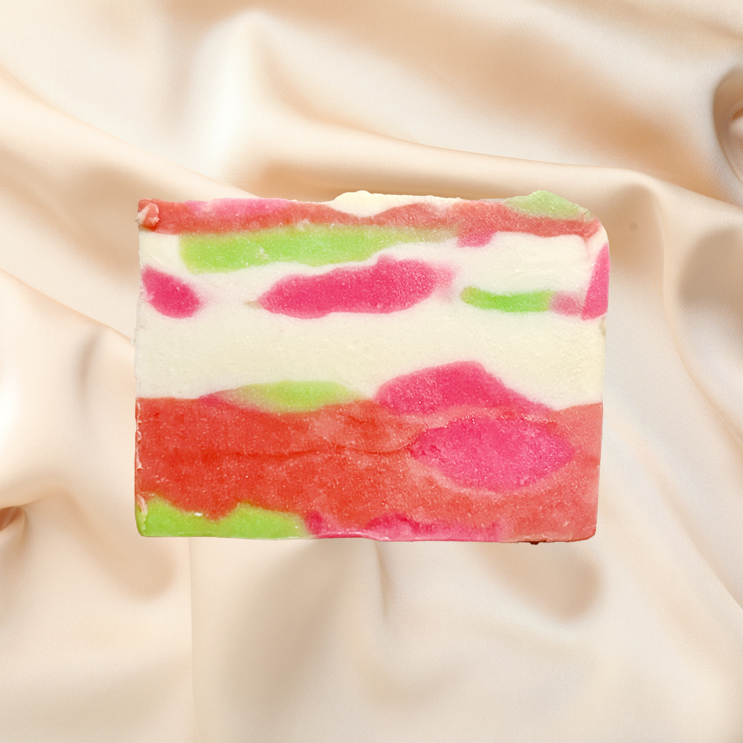 Colorful soap bar with pink and green patterns on a beige fabric background