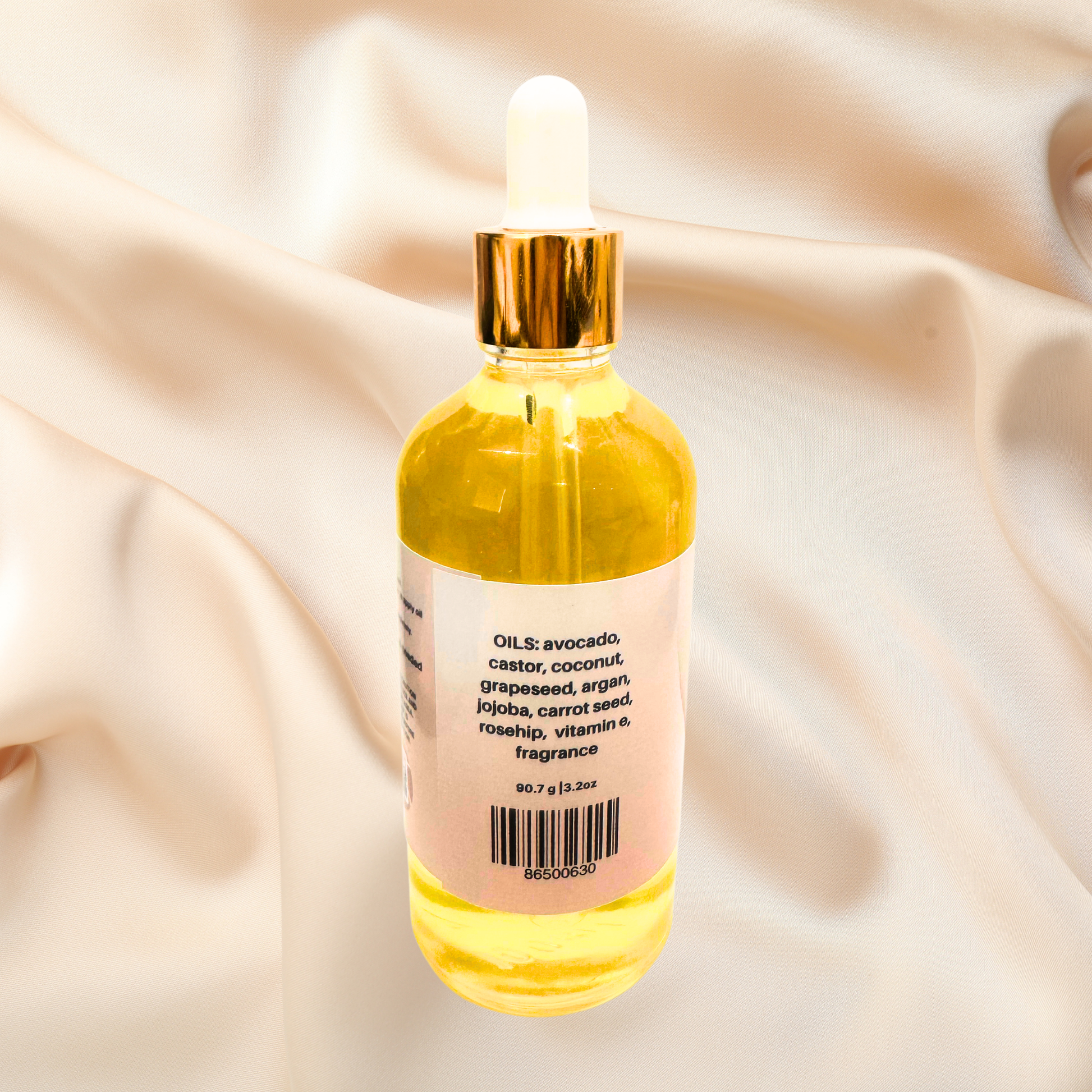 Bottle of yellow oil with a dropper on a beige fabric background