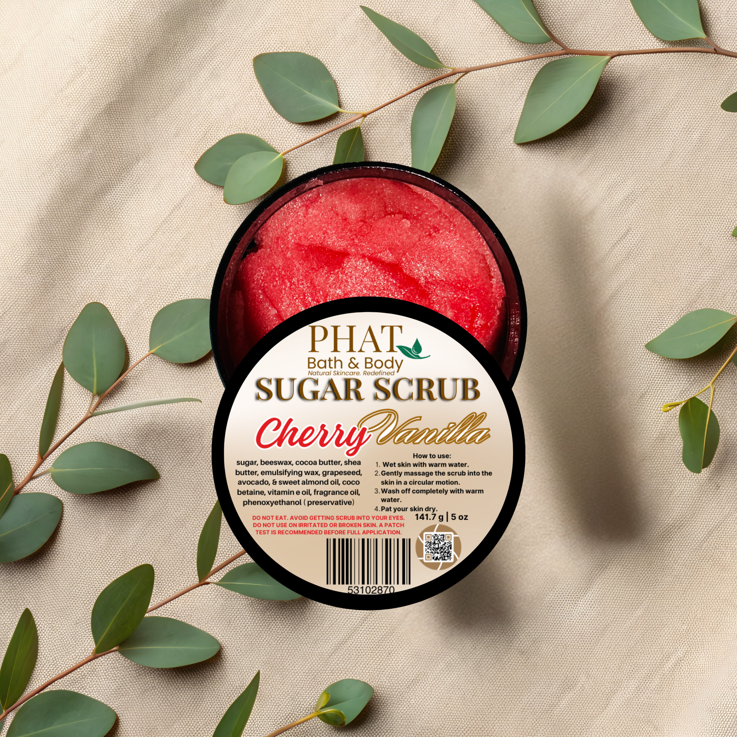 Jar of cherry vanilla sugar scrub with eucalyptus leaves on a beige fabric background