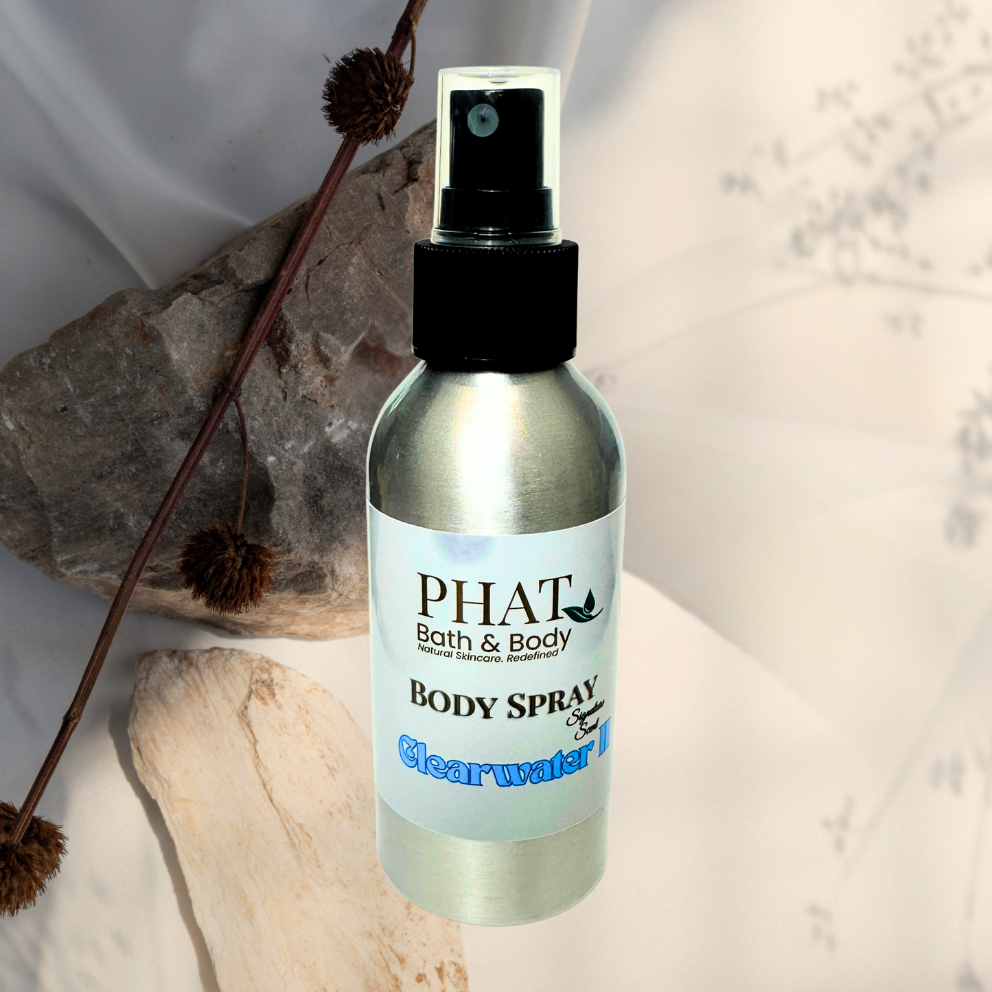 Body spray bottle labeled 'PHAT Bath & Body' on a neutral background with decorative elements.