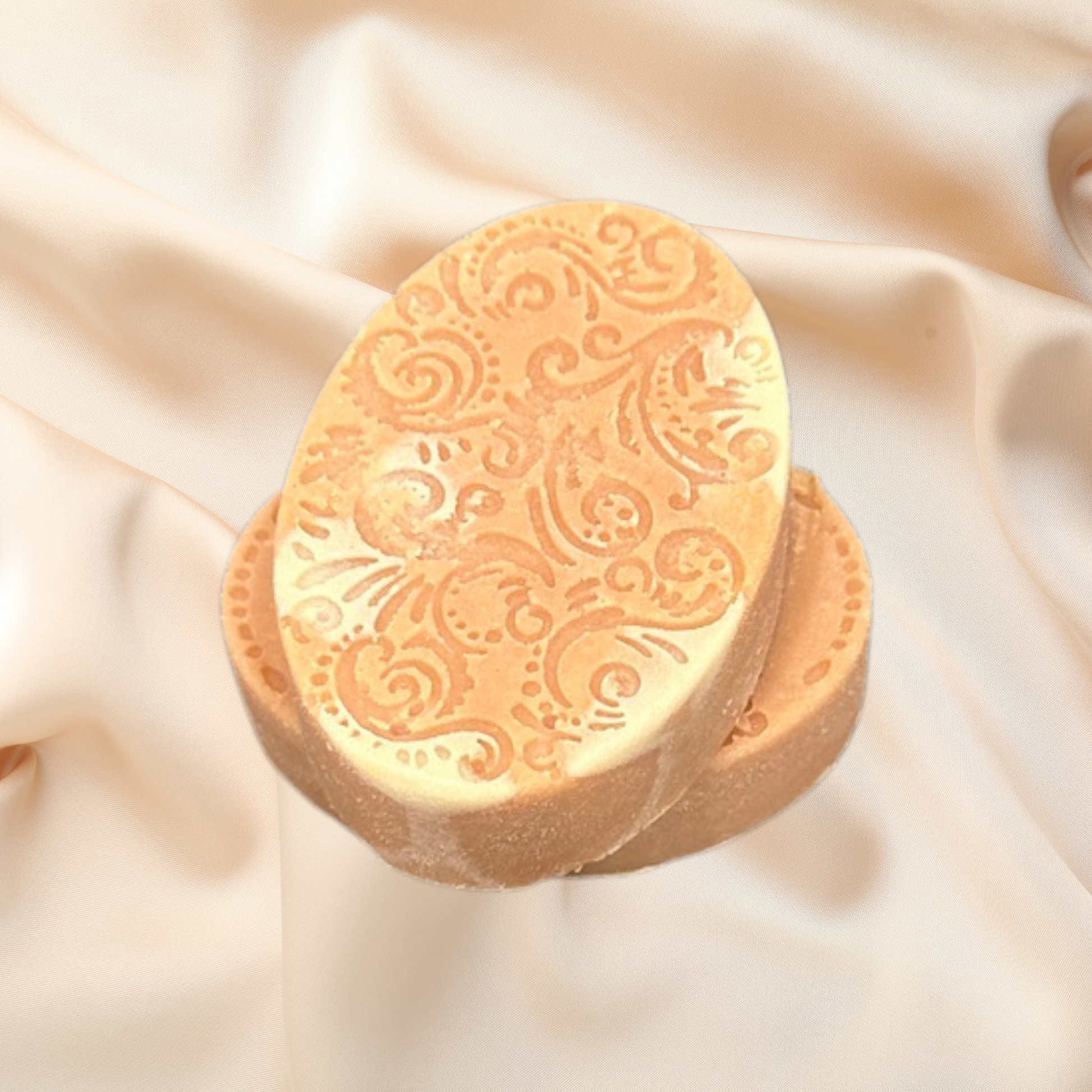 Decorative soap bar with intricate patterns on a soft beige fabric background