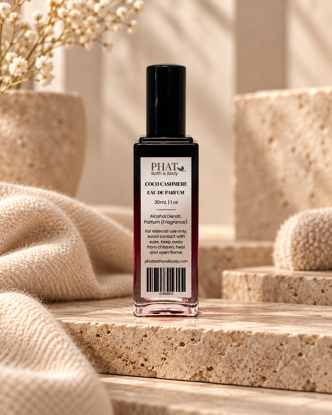 Back label of the Coco Cashmere unisex Eau de Parfum bottle styled with soft neutral textures and natural stone.