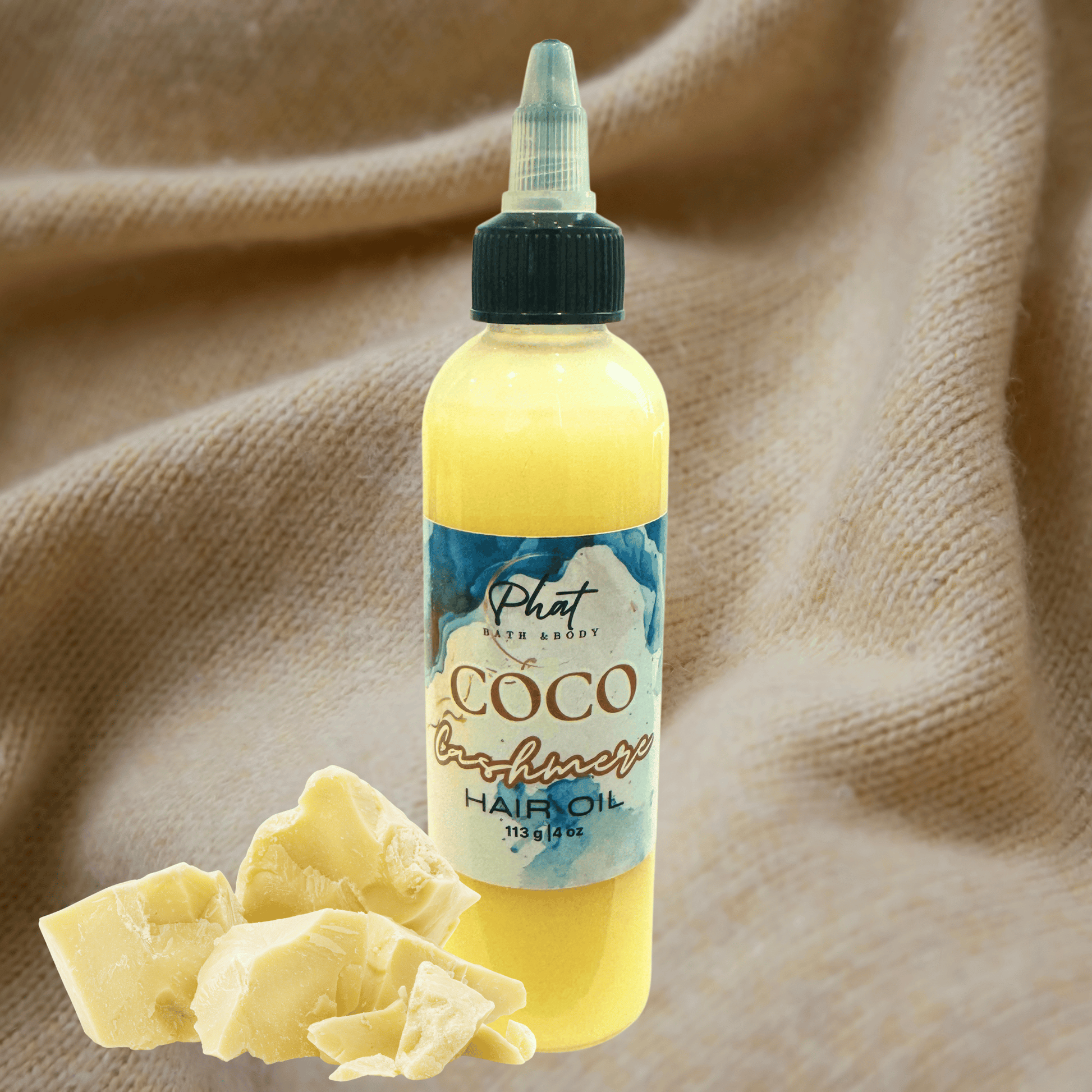 Bottle of Coco Cashmere hair growth oil with a label on a beige cashmere background