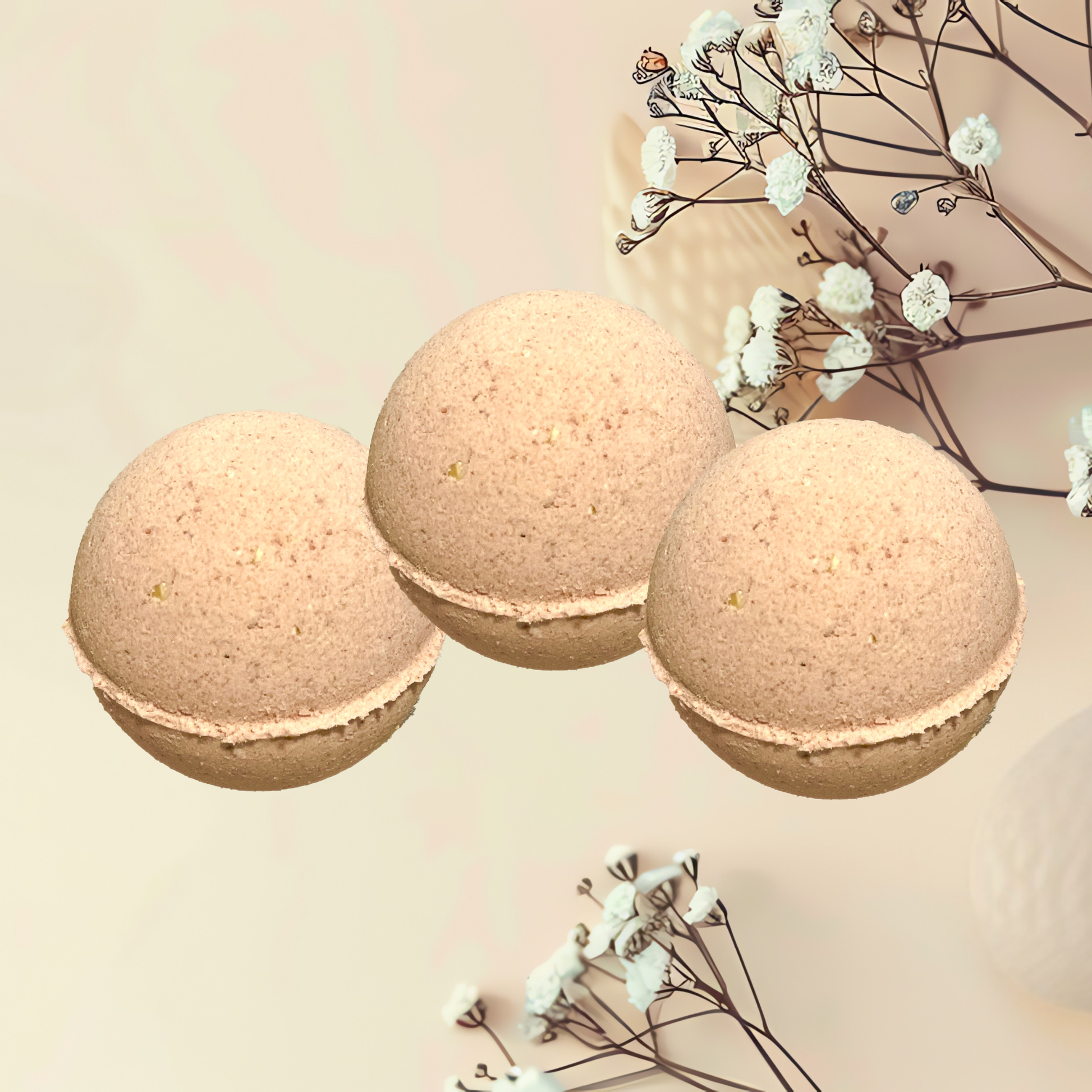 Three beige bath bombs with white flowers on a light background