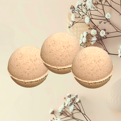 Three beige bath bombs with white flowers on a light background
