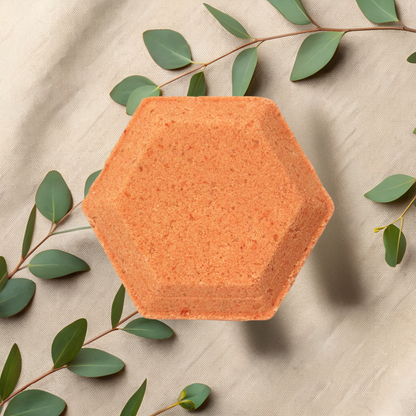 Hexagonal orange steamer with green leaves on a beige fabric background
