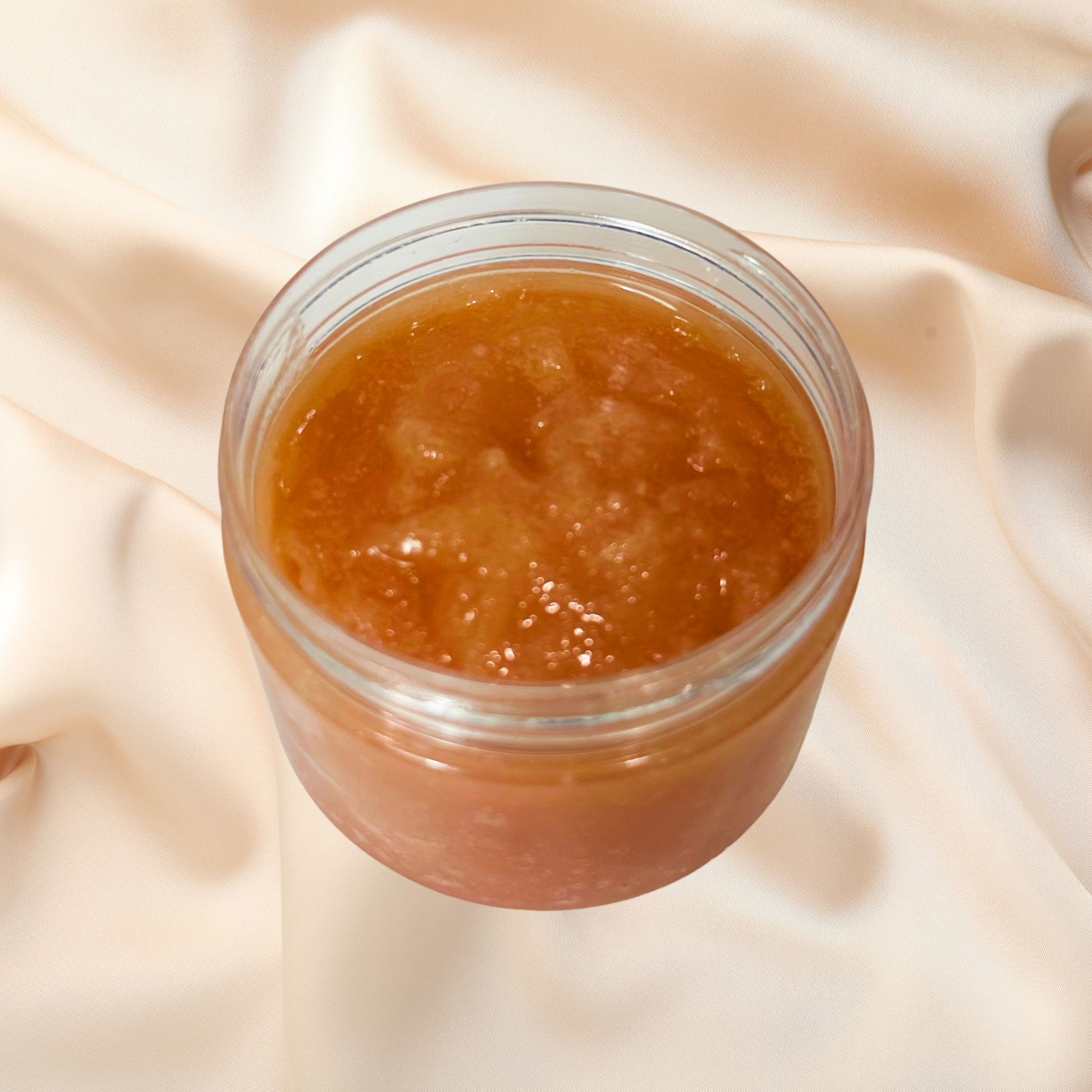 Jar of brown scrub on a beige fabric background