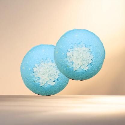 Two blue bath bombs with visible sea salt on a beige background